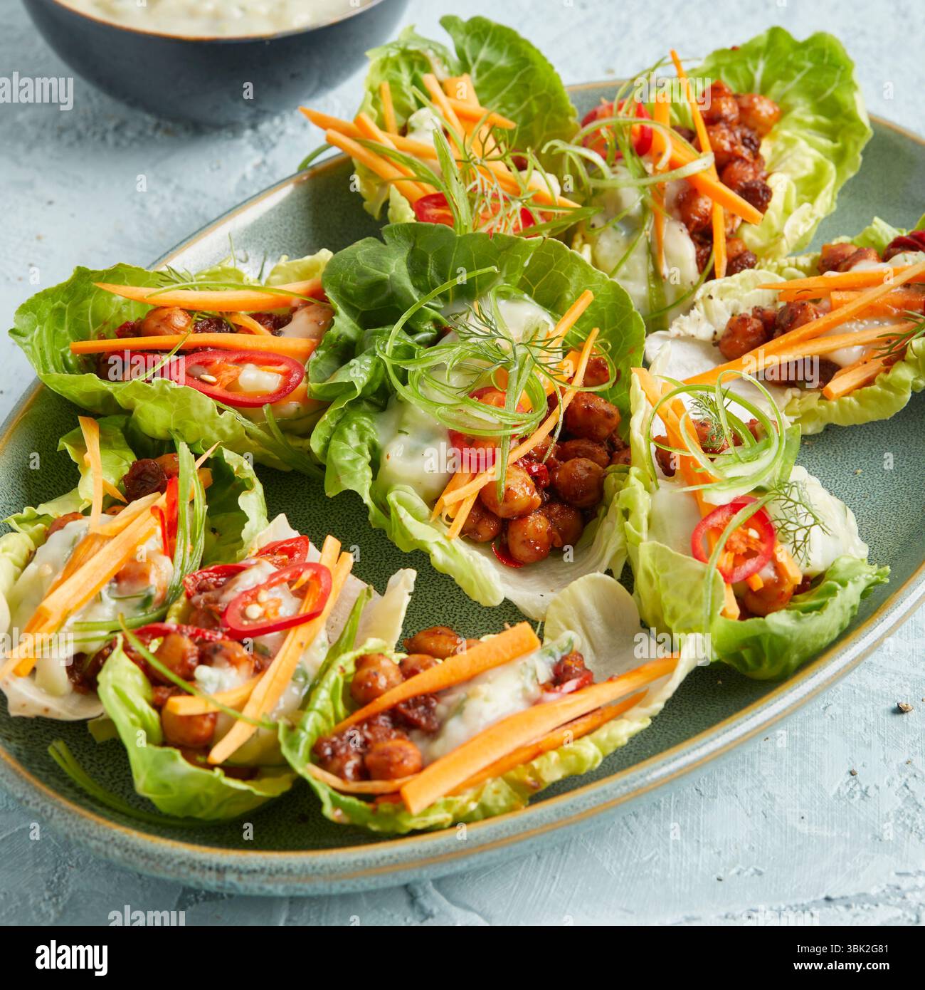 Ceci in una foglia di lattuga con yogurt: Un antipasto o uno spuntino leggero a base di piante, perfetto per mangiare in modo pulito, per preparare cibi, pranzi estivi, ricchi di proteine Foto Stock
