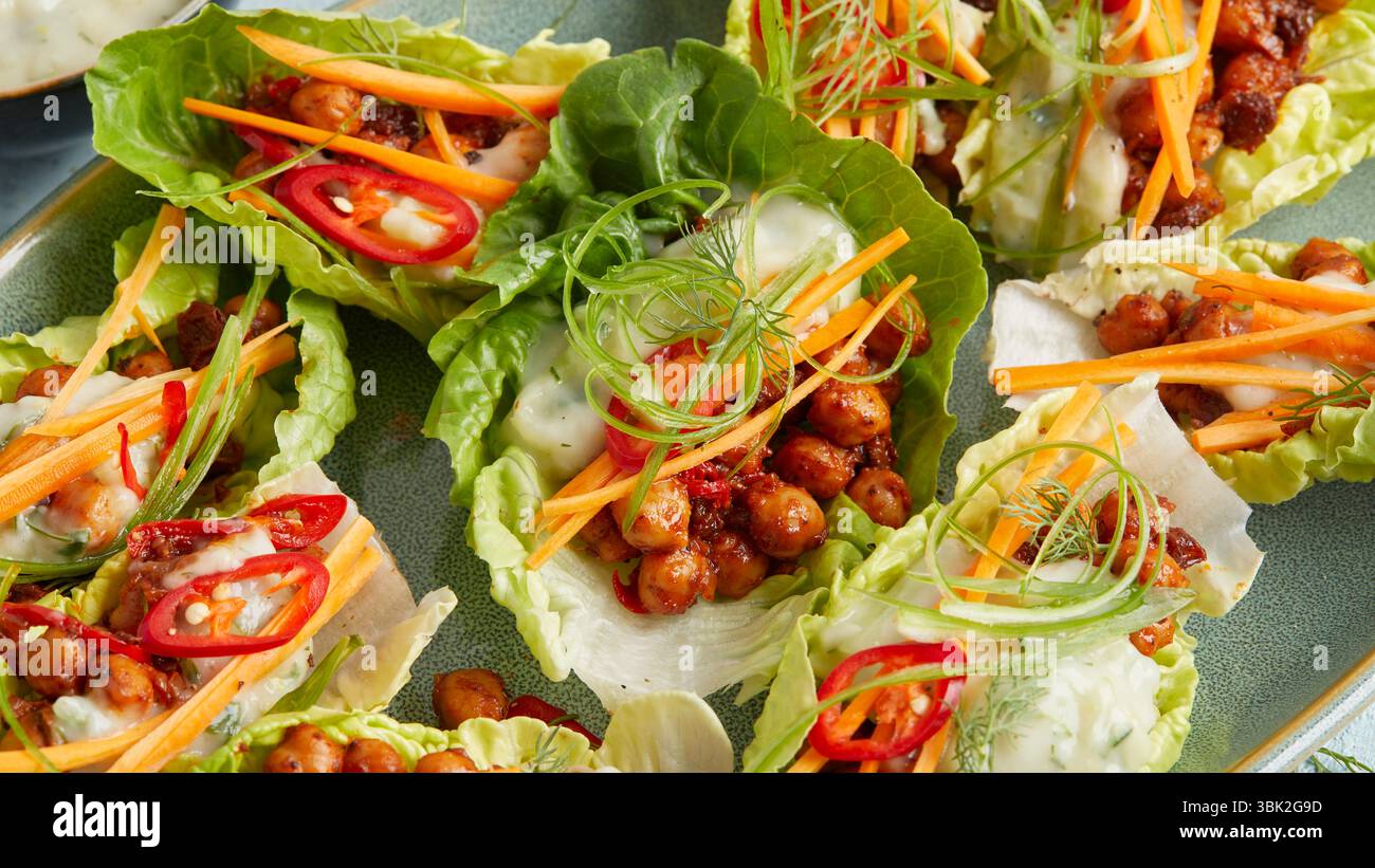 Ceci in una foglia di lattuga con yogurt: Un antipasto o uno spuntino leggero a base di piante, perfetto per mangiare in modo pulito, per preparare cibi, pranzi estivi, ricchi di proteine Foto Stock