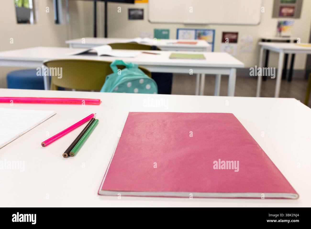 Aula con quaderni e matite sulla scrivania, pronta per le attività didattiche, a scuola Foto Stock