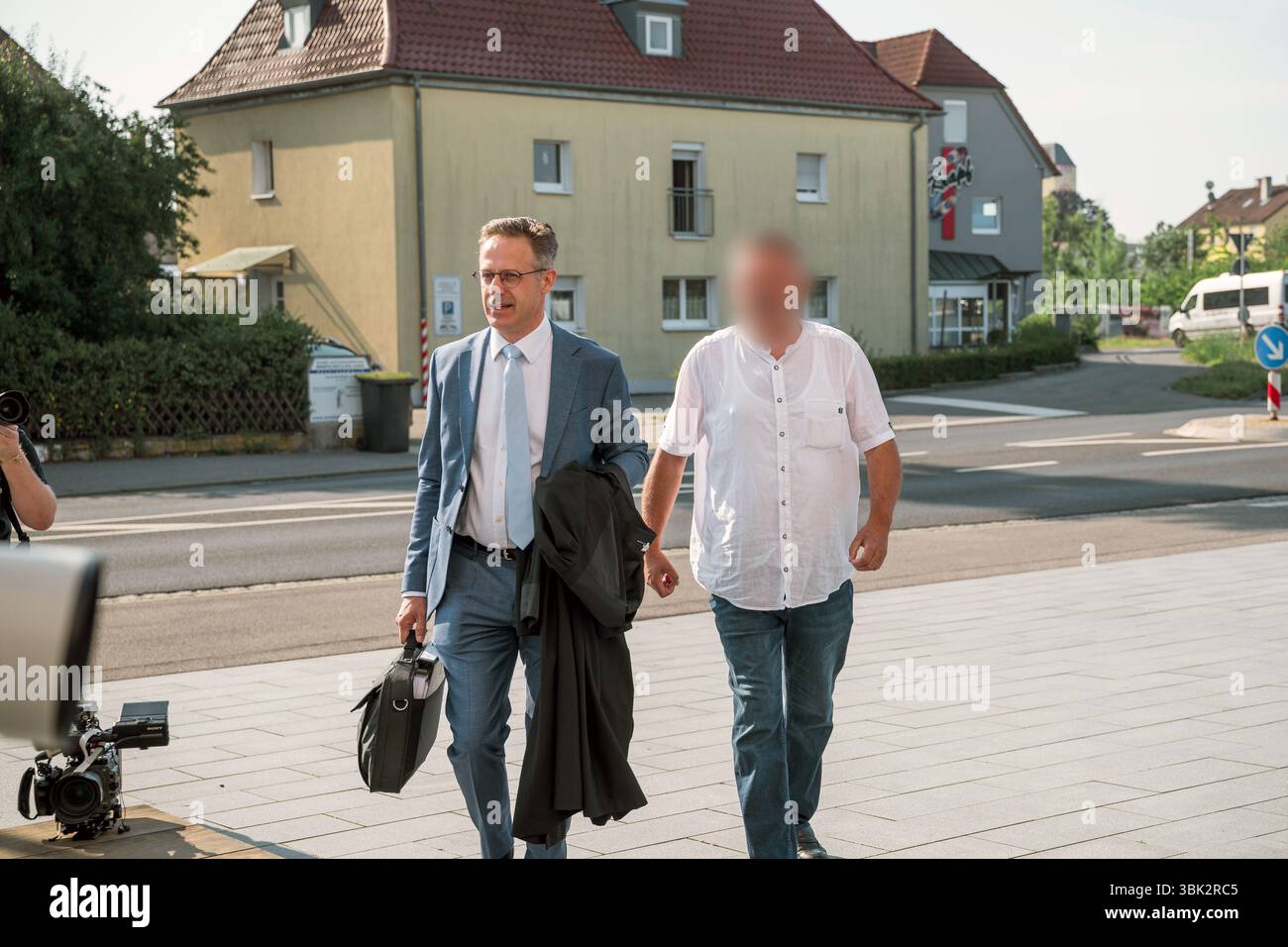 18 giugno 2025, Baviera, Haßfurt: Marcus Pretzell (l), avvocato, accompagna il suo cliente (r) al tribunale locale all'inizio del suo processo per l'uso di simboli di organizzazioni incostituzionali e terroristiche e per l'istigazione del popolo. Nella primavera del 2024, l'accusato avrebbe caricato un file immagine su X con una foto ritratto dell'allora ministro federale dell'economia Habeck (Verdi) e le parole "Schwachkopf PROFESSIONAL". Ciò ha portato a un raid nella casa del sospetto nel distretto di Haßberge nella bassa Franconia. Foto: Daniel Vogl/dpa - ATTENZIONE: L'imputato/i imputato/i è/sono stato/sono stati pixellati per la lega Foto Stock
