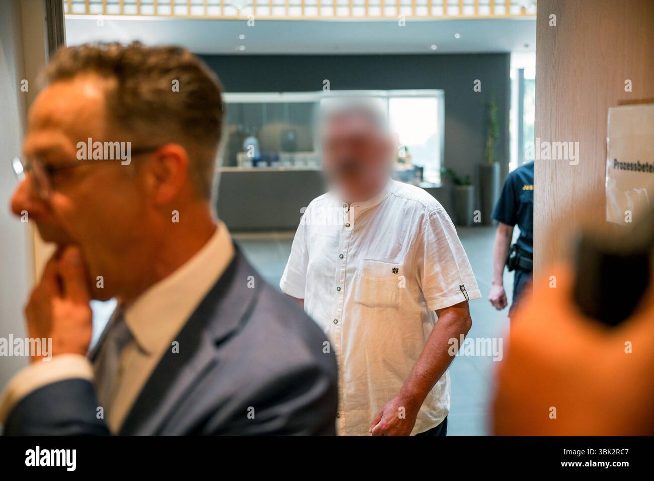 18 giugno 2025, Baviera, Haßfurt: L'imputato (M) entra in tribunale all'inizio del processo per aver usato segni di organizzazioni incostituzionali e terroristiche e per istigazione all'odio. Nella primavera del 2024, l'accusato avrebbe caricato un file immagine su X con una foto ritratto dell'allora ministro federale dell'economia Habeck (Verdi) e le parole "Schwachkopf PROFESSIONAL". Ciò ha portato a un raid nella casa del sospetto nel distretto di Haßberge nella bassa Franconia. Foto: Daniel Vogl/dpa - ATTENZIONE: L'imputato/i imputato/i è/sono stato/sono stati pixellati per motivi legali Foto Stock