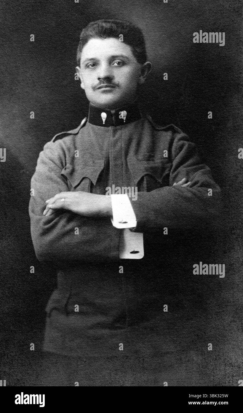 Un ritratto in bianco e nero del periodo della prima guerra mondiale di un militare delle truppe dell'aviazione austro-ungarica (Kaiserliche und Königliche Luftfahrtruppen o k.u.k. Luftfahrtruppen). Questa unità era la forza aerea dell'Impero austro-ungarico, che era operativa sia sul fronte orientale che su quello italiano. Ha dei baffi arricciati al manubrio ed è in piedi con orgoglio con le braccia piegate. Indossa l'insegna del palloncino K.u.k. Luftfahrtruppen sui collari della sua tunica uniforme. Foto Stock