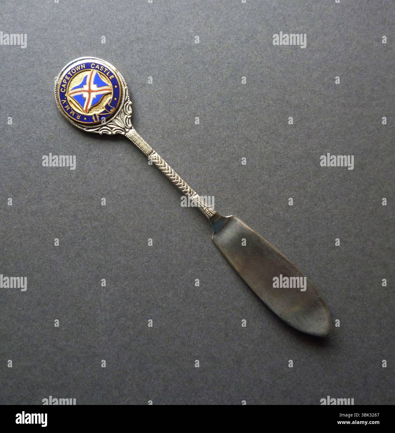 Un coltello da burro vintage placcato in argento prodotto come souvenir per la linea passeggeri della Union-Castle Line, R.M.M.V. Capetown Castle. Questa nave era un transatlantico passeggeri britannico costruito dalla Harland & Wolff a Belfast per il servizio postale della Union-Castle Line da Southampton al Sudafrica. La nave fu varata il 23 settembre 1937 e fece il suo viaggio inaugurale il 29 aprile 1938. Foto Stock