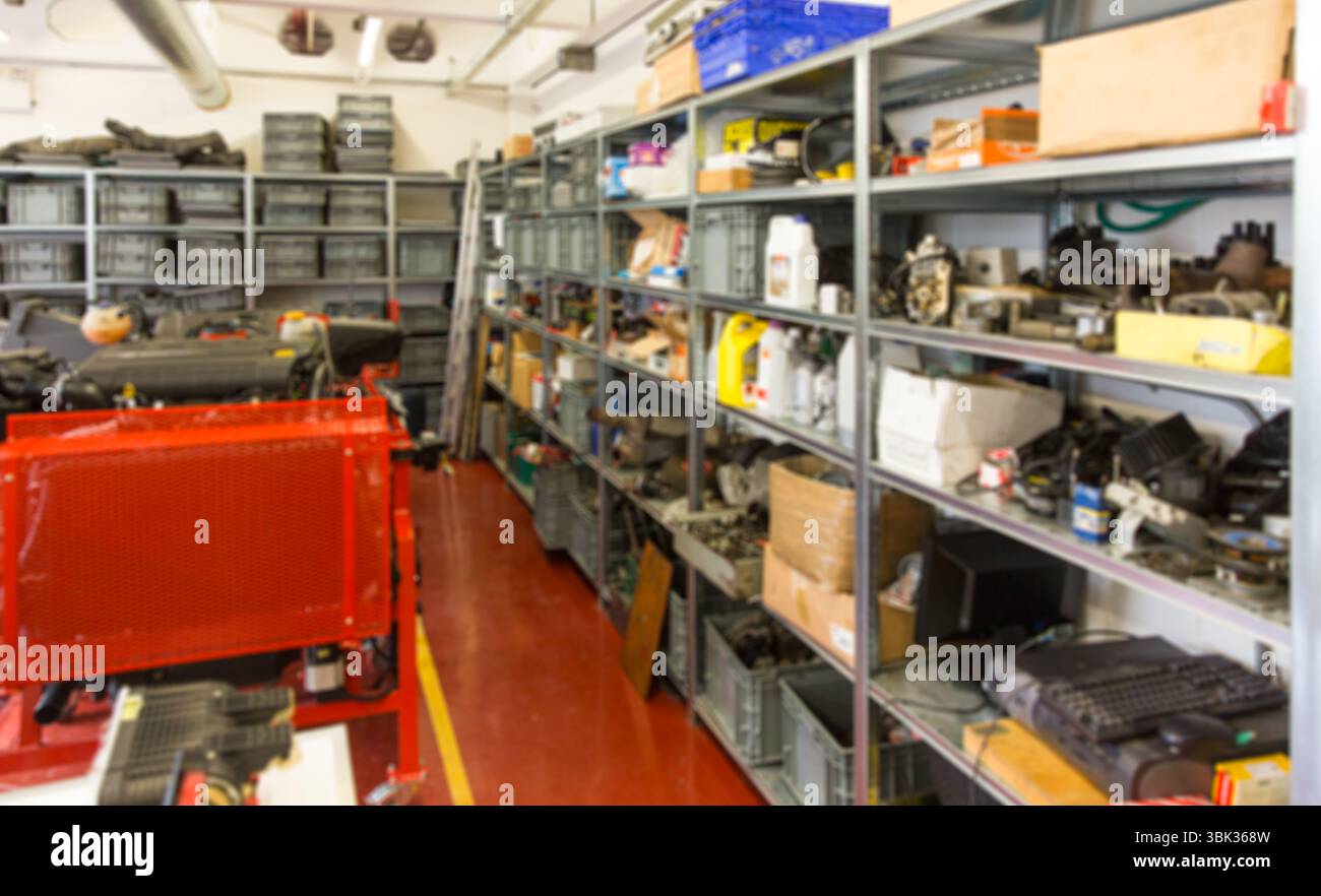 La macchina industriale rossa si trova in un magazzino di officina con design piatto, con scaffalature e contenitori in plastica Foto Stock
