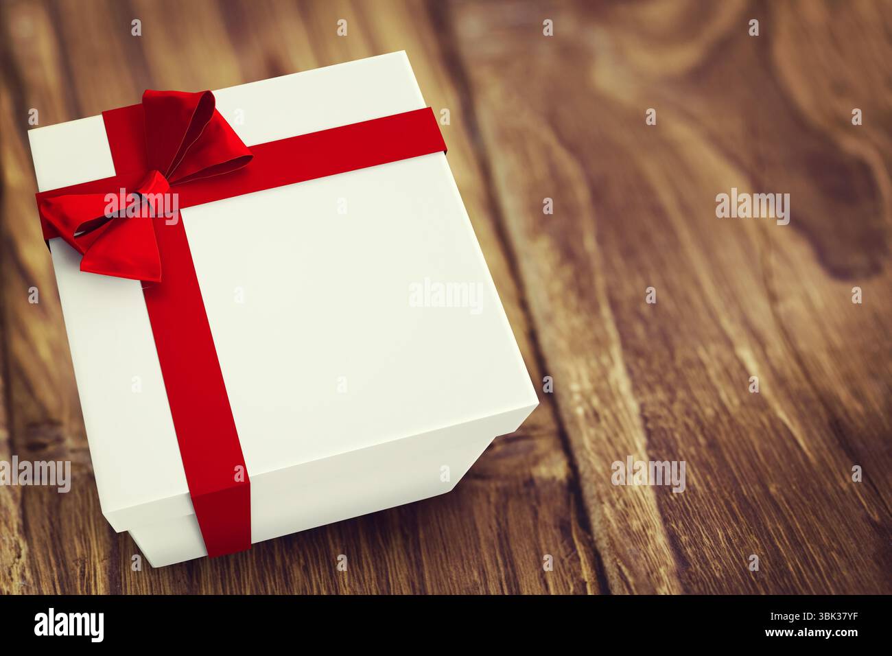 La confezione regalo bianca con nastro in raso rosso è posizionata su un tavolo in legno rustico, dal design piatto Foto Stock