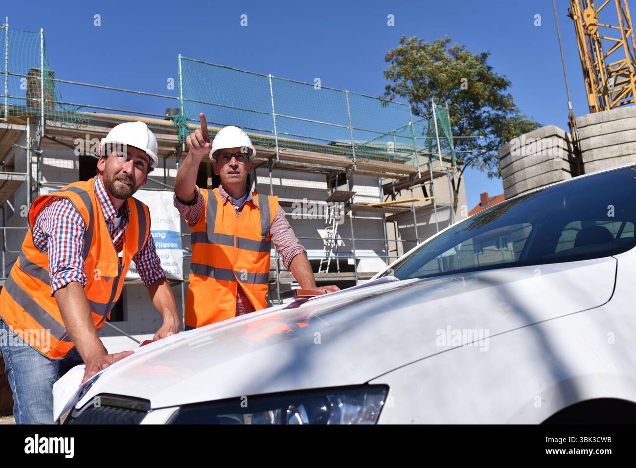 Il lavoro di squadra sul sito in costruzione - site manager e architetto sul sito durante la costruzione di una casa Foto Stock