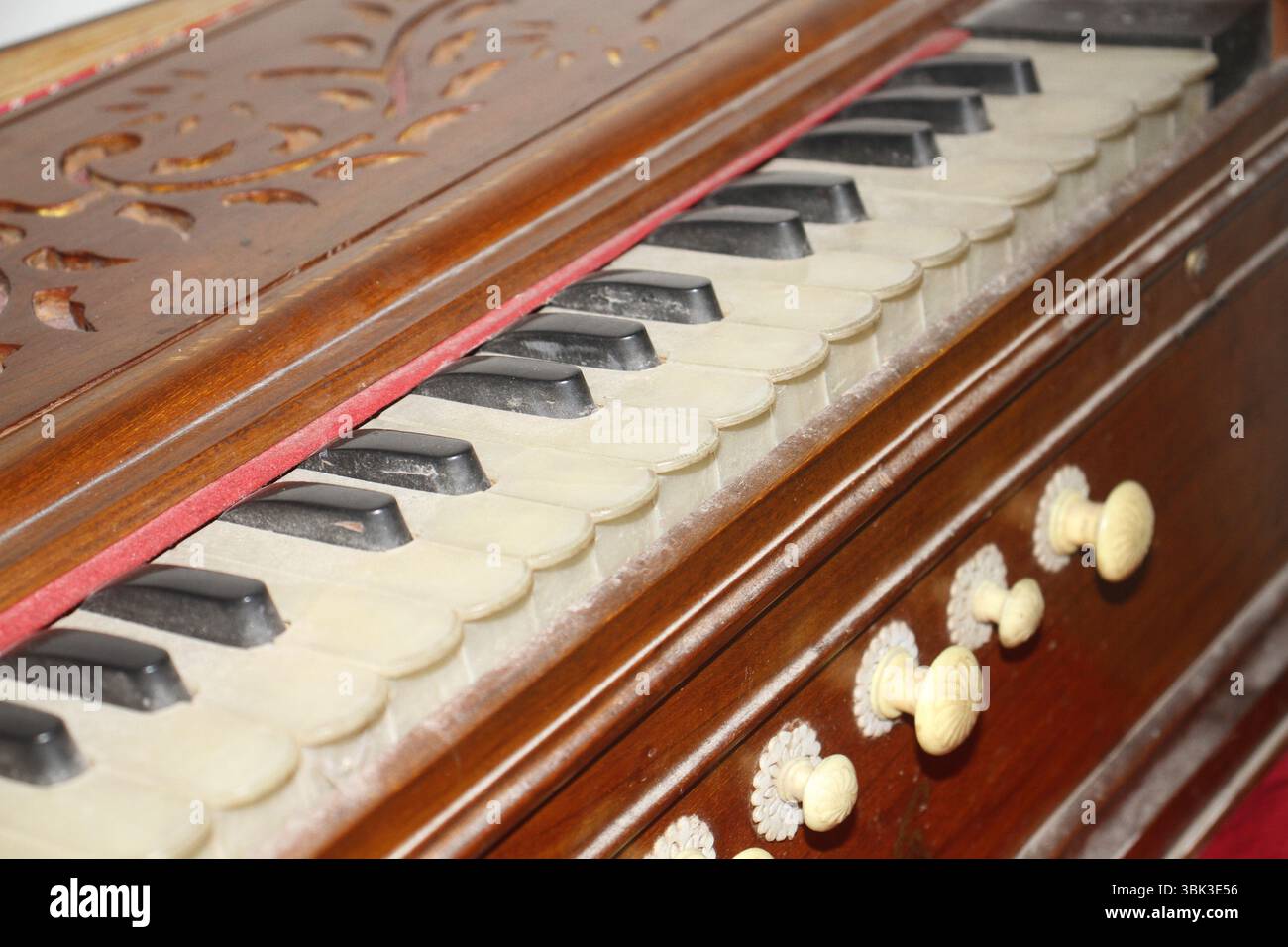 Un primo piano di un armonium antico, uno strumento musicale tradizionale. La fotografia evidenzia i tasti neri e di colore avorio. Foto Stock