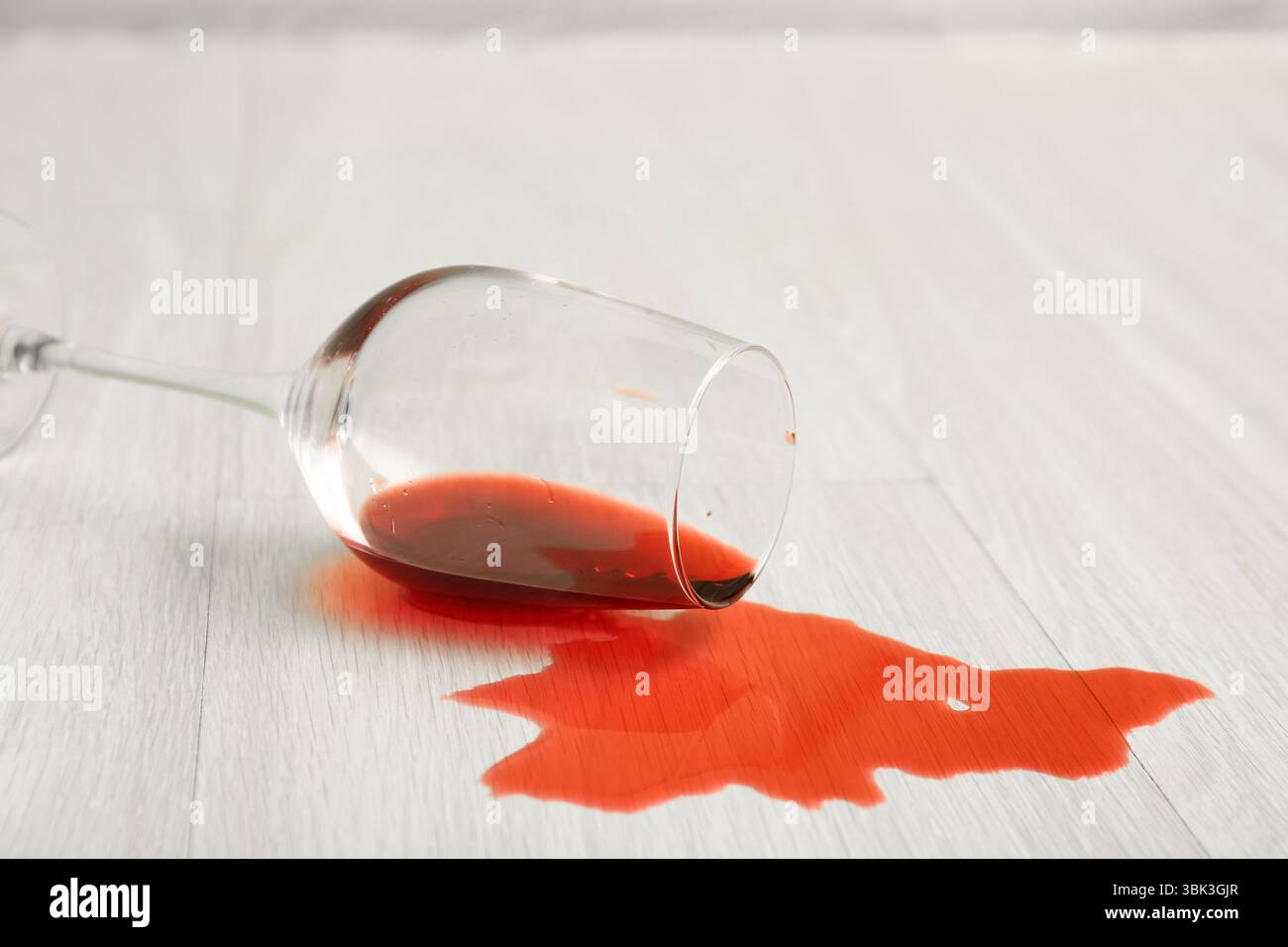 Pavimento in laminato di legno con bicchiere di vino rovesciato Foto Stock