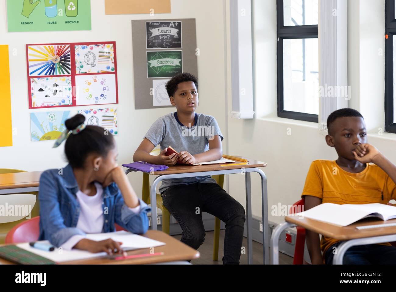 Studenti diversi in classe ascoltando attentamente durante la lezione, coinvolgendo l'insegnante, a scuola Foto Stock