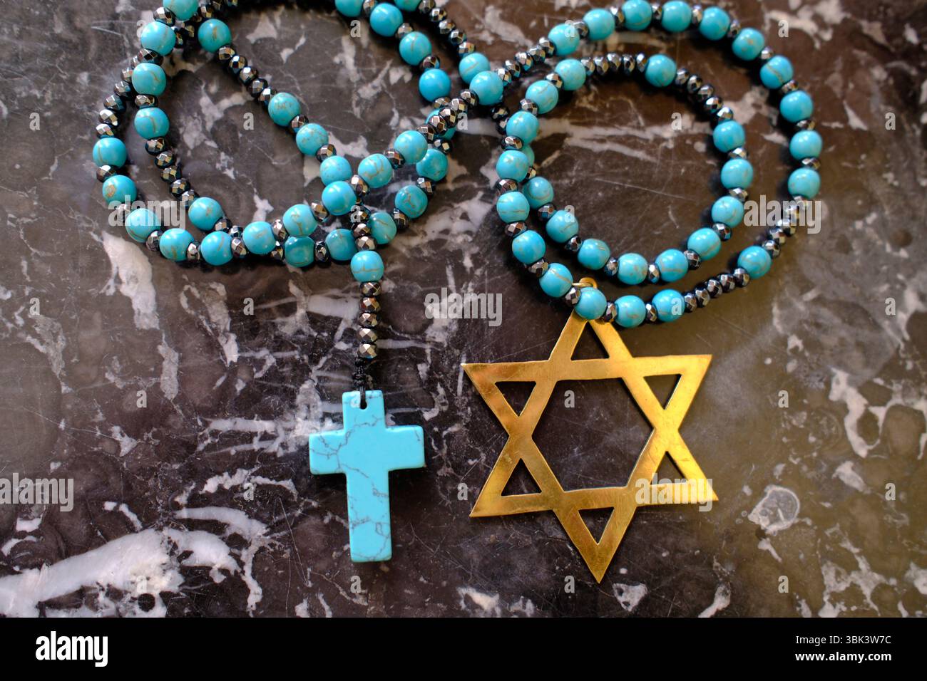 Due religioni monoteiste, il cristianesimo e l'ebraismo. Un rosario e una stella di David. Simboli religiosi. Foto Stock