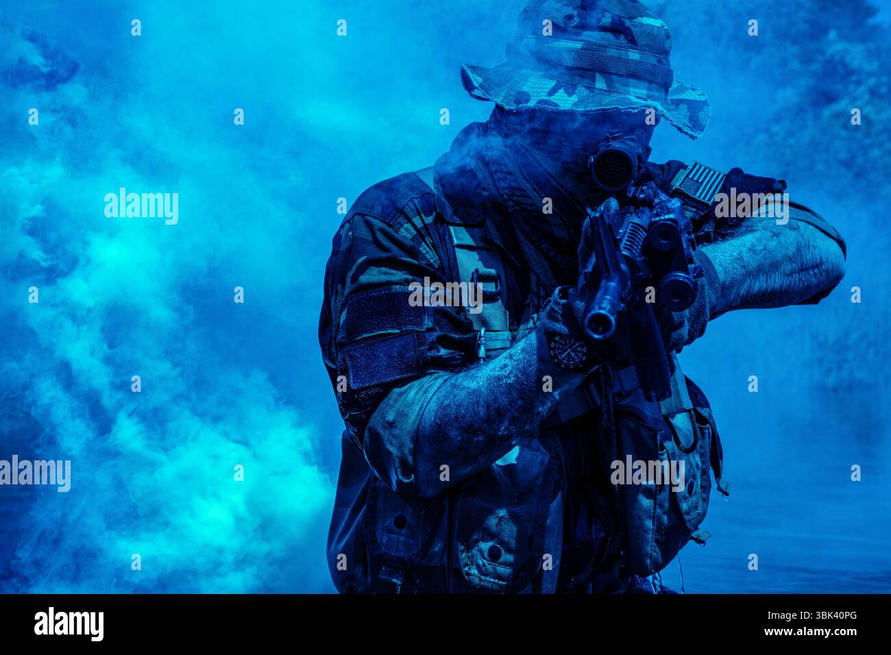Soldato in abito mimetico con fucile e equipaggiamento tattico che mira al fumo blu in una scena dinamica e intensa. Foto Stock