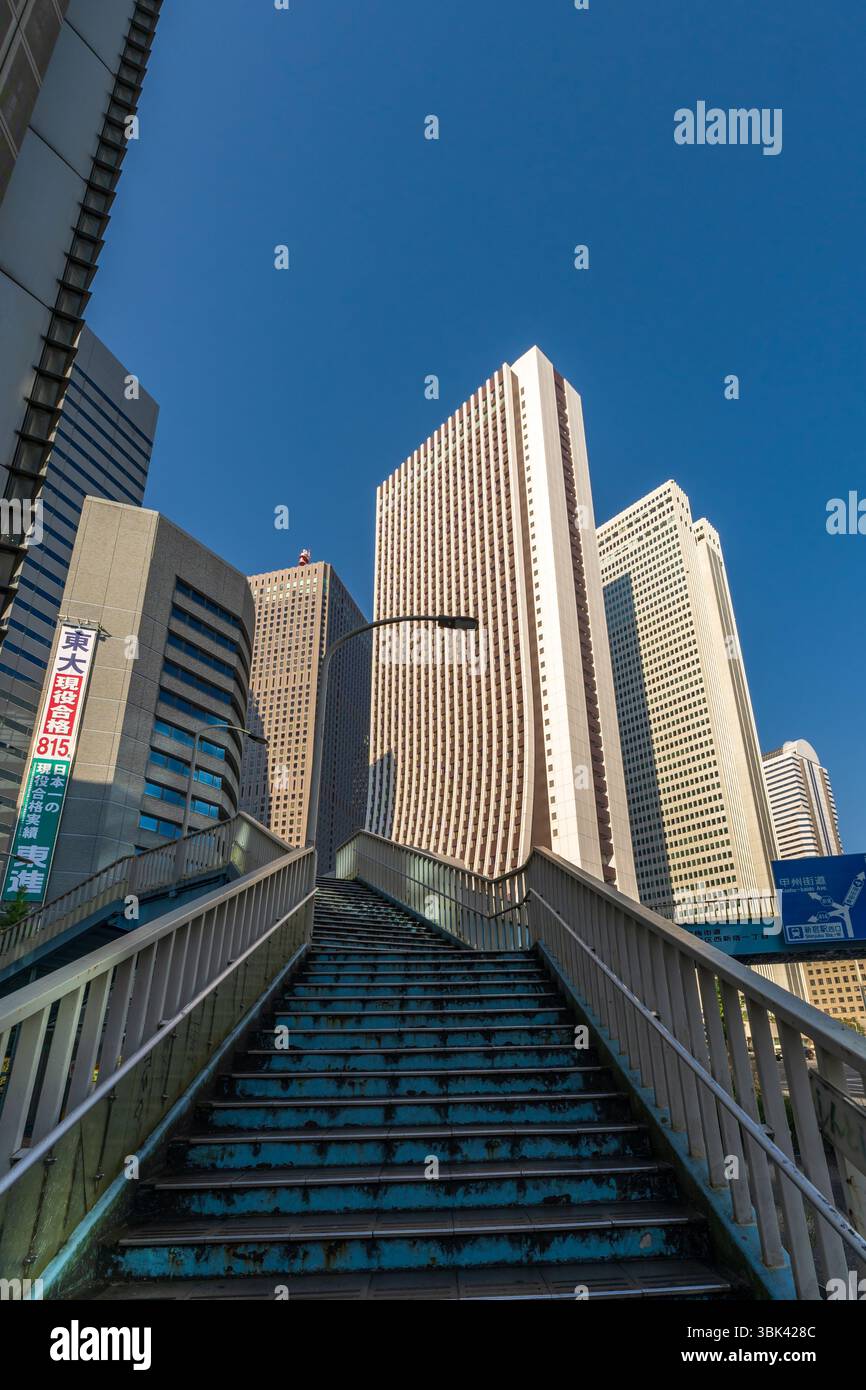 Ponte pedonale con moderni grattacieli e cielo blu - Shinjuku, Tokyo, Giappone Foto Stock