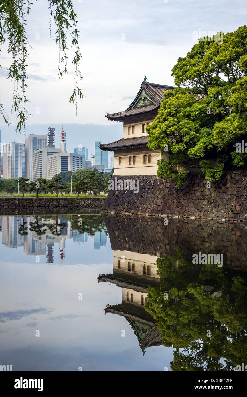 Il fossato di Kikyo-bori intorno al vecchio castello di Edo con la torre di guardia Sakurada Tatsumi Yagura e i moderni grattacieli della città di Tokyo sullo sfondo Foto Stock