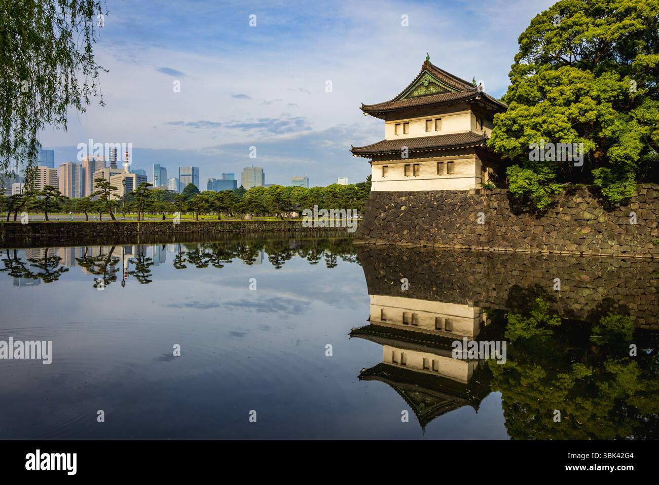Il fossato di Kikyo-bori intorno al vecchio castello di Edo con la torre di guardia Sakurada Tatsumi Yagura e i moderni grattacieli della città di Tokyo sullo sfondo. Foto Stock