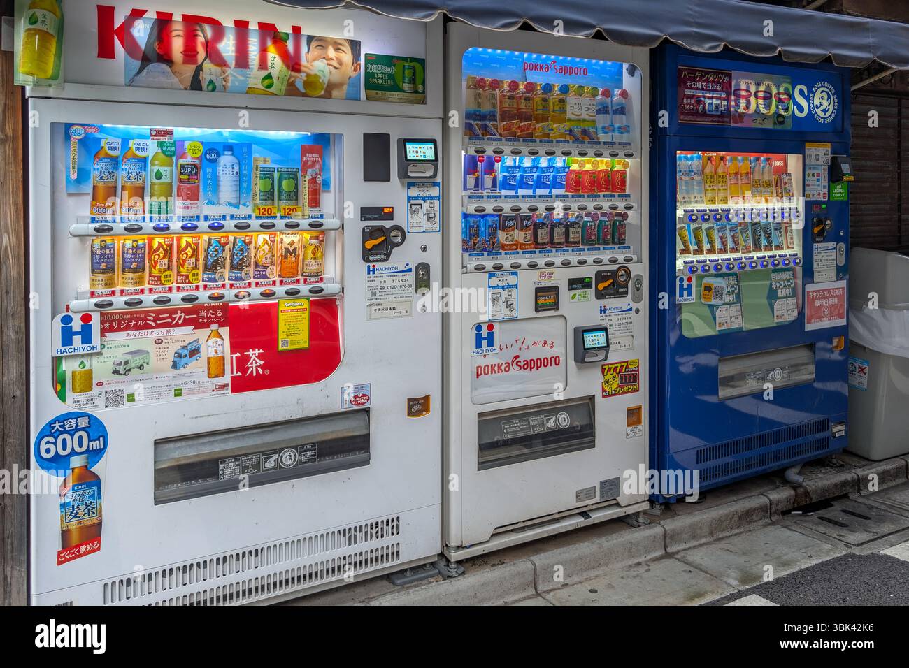Fila di distributori automatici a Tokyo, Giappone. Il Giappone ha una delle più alte densità di distributori automatici al mondo. Foto Stock