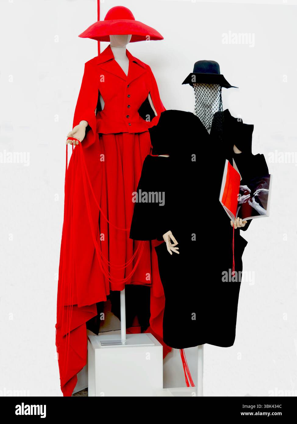 Manichini che espongono l'abbigliamento audace avant-Garde rosso e nero su sfondo bianco Foto Stock