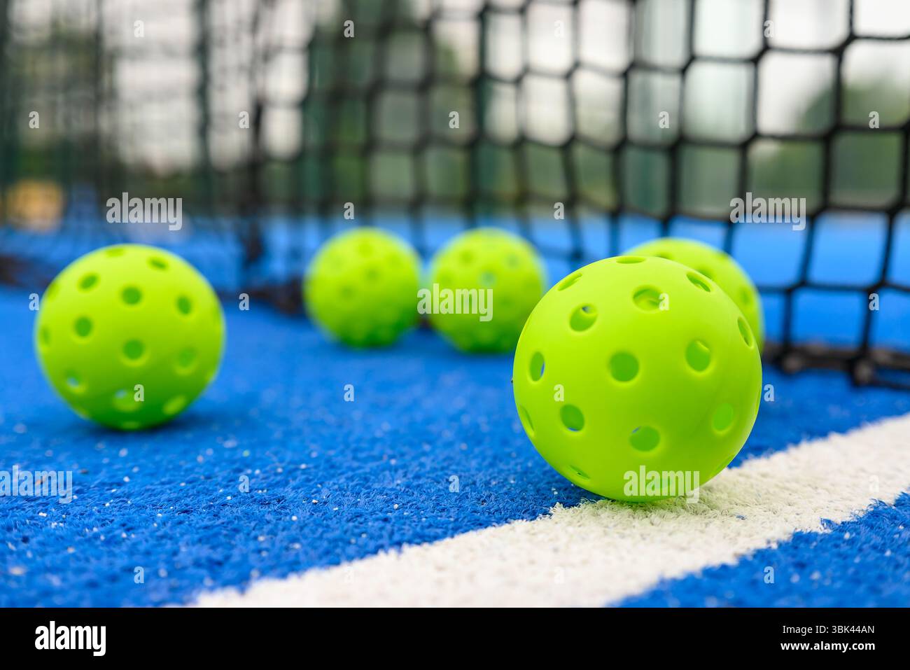vista in piano di sei palline da picchetto vicino alla rete in un campo blu Foto Stock