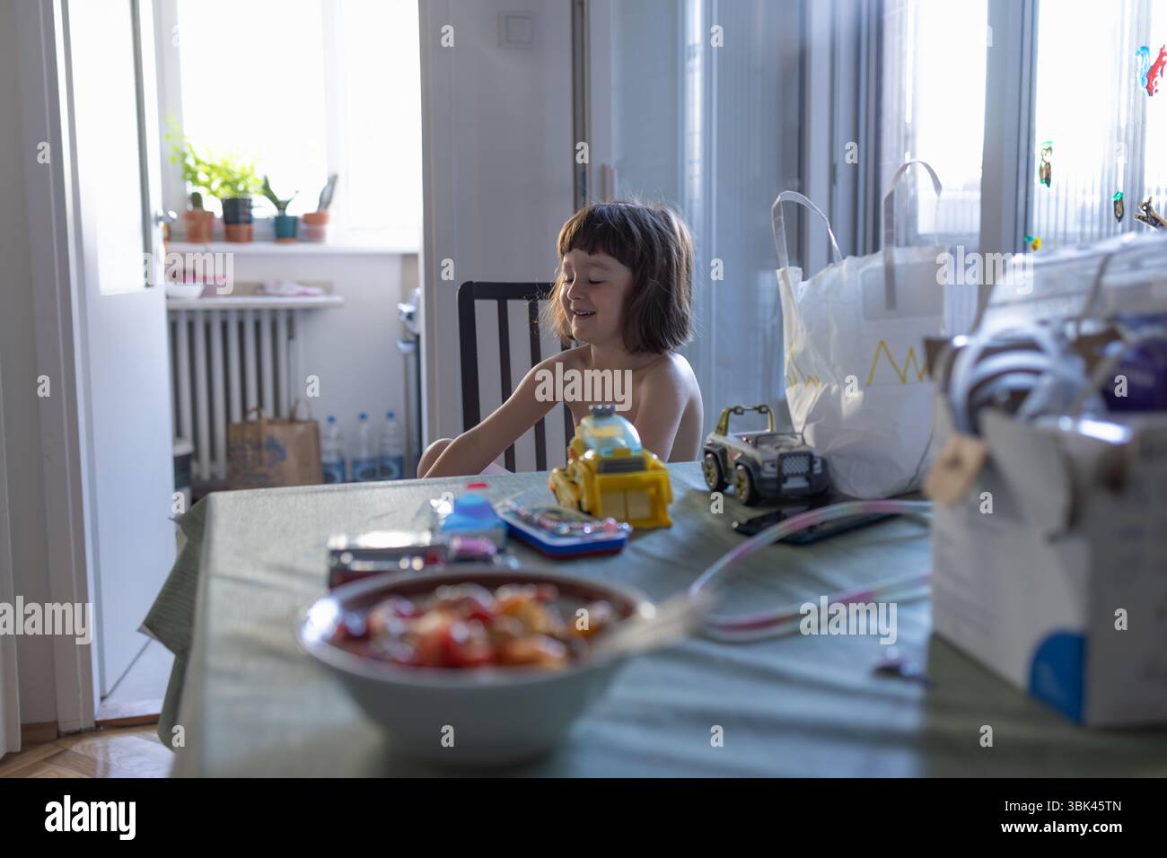Un ragazzino sorridente a tavola. La vita di tutti i giorni. Foto Stock