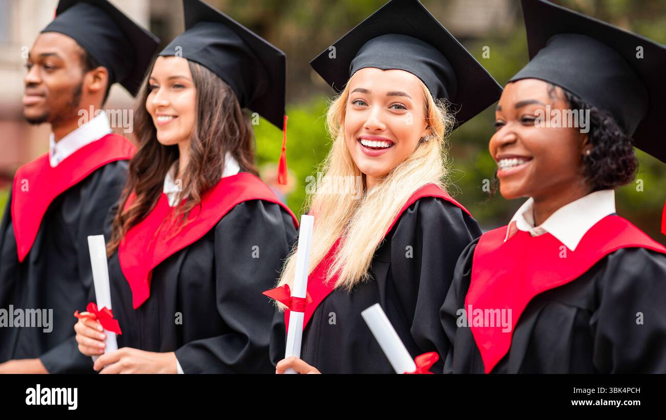 Bella signora bionda in piedi tra il gruppo internazionale di studenti Foto Stock