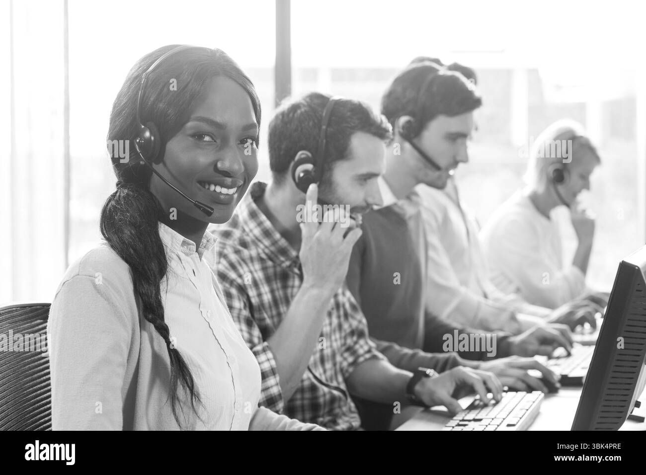 Immagine di persone aziendali diverse che utilizzano cuffie telefoniche in ufficio Foto Stock