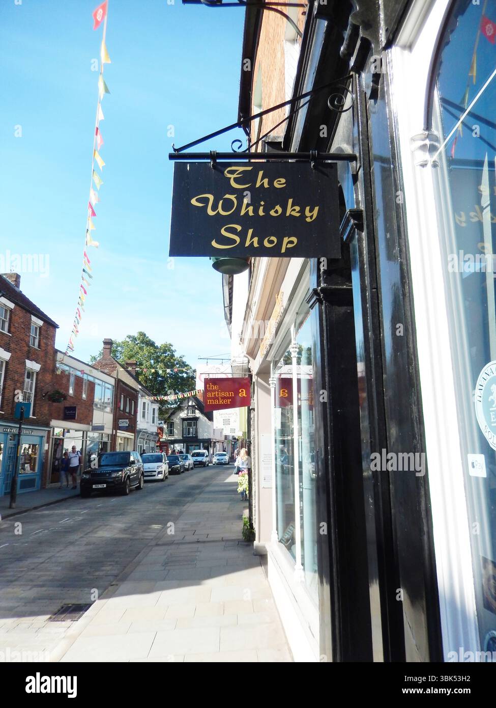 Affascinante scena di strada con negozi boutique e decorazioni festose colorate. Lincoln, Inghilterra Foto Stock