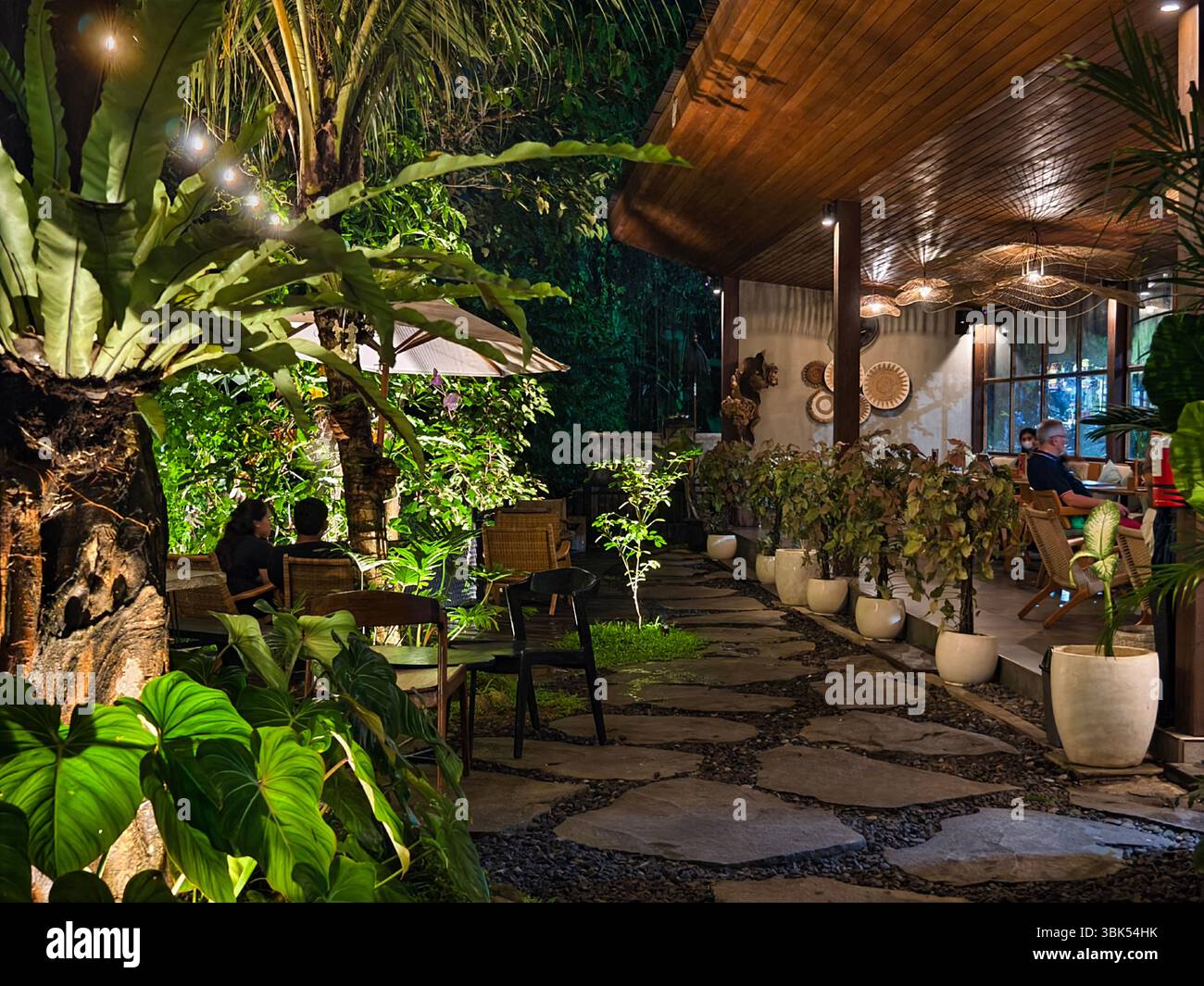 Ubud, Bali, Indonesia - 11 maggio 2025: Tropical Night Outdoor Café e un accogliente rifugio nel giardino Foto Stock