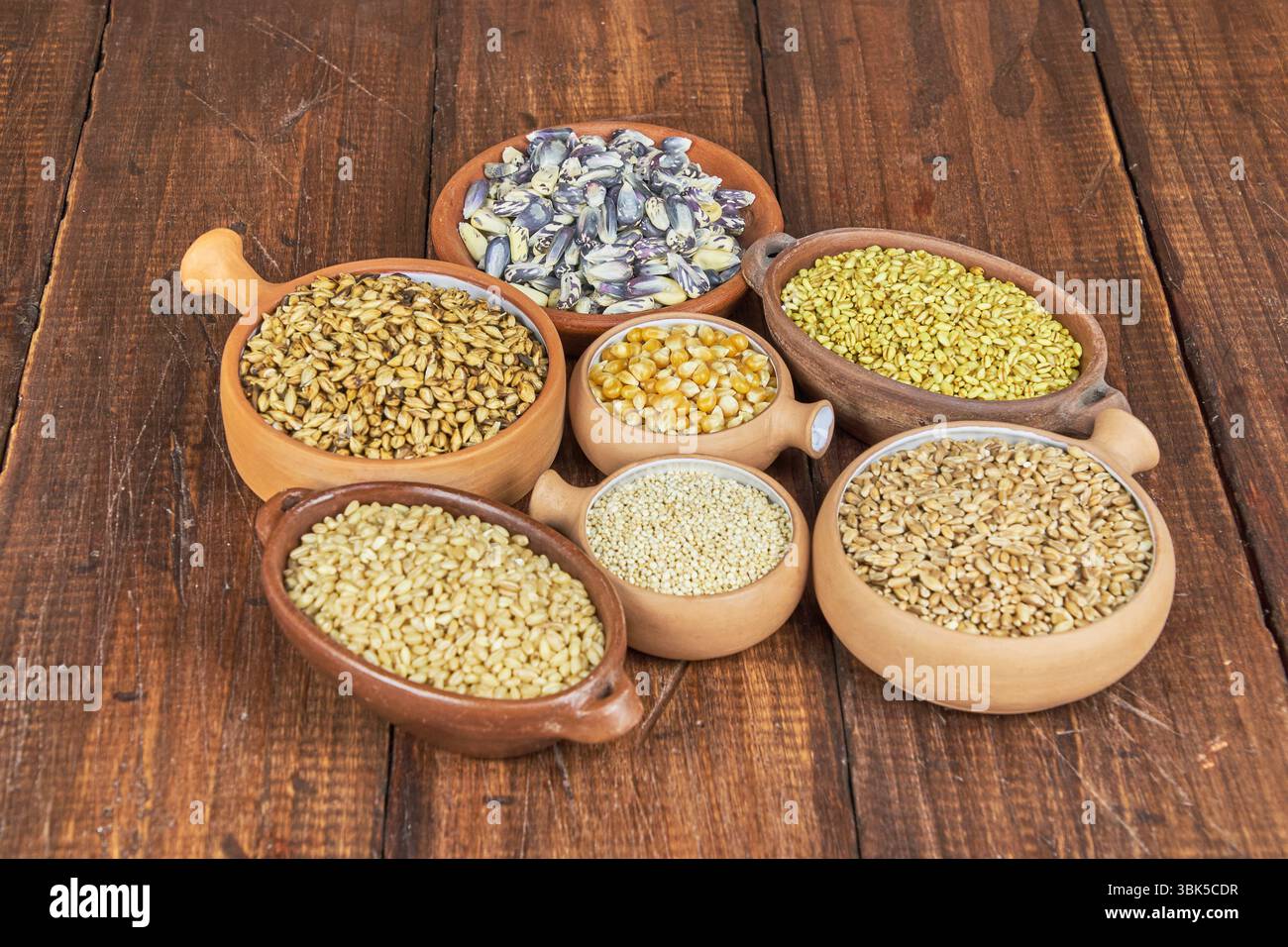 Concetto di grani interi. Un colorato mix di cereali interi: Grano, mais e quinoa. Ingredienti per una dieta sana, attenzione selettiva. Foto Stock
