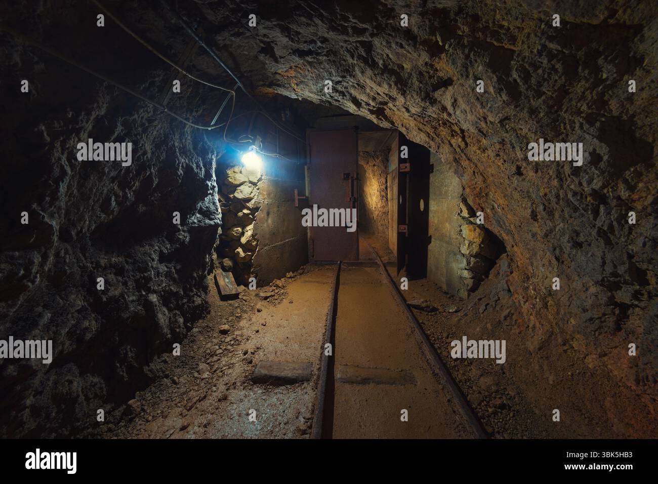 Mina sotterranea passaggio con rotaie e luce Foto Stock