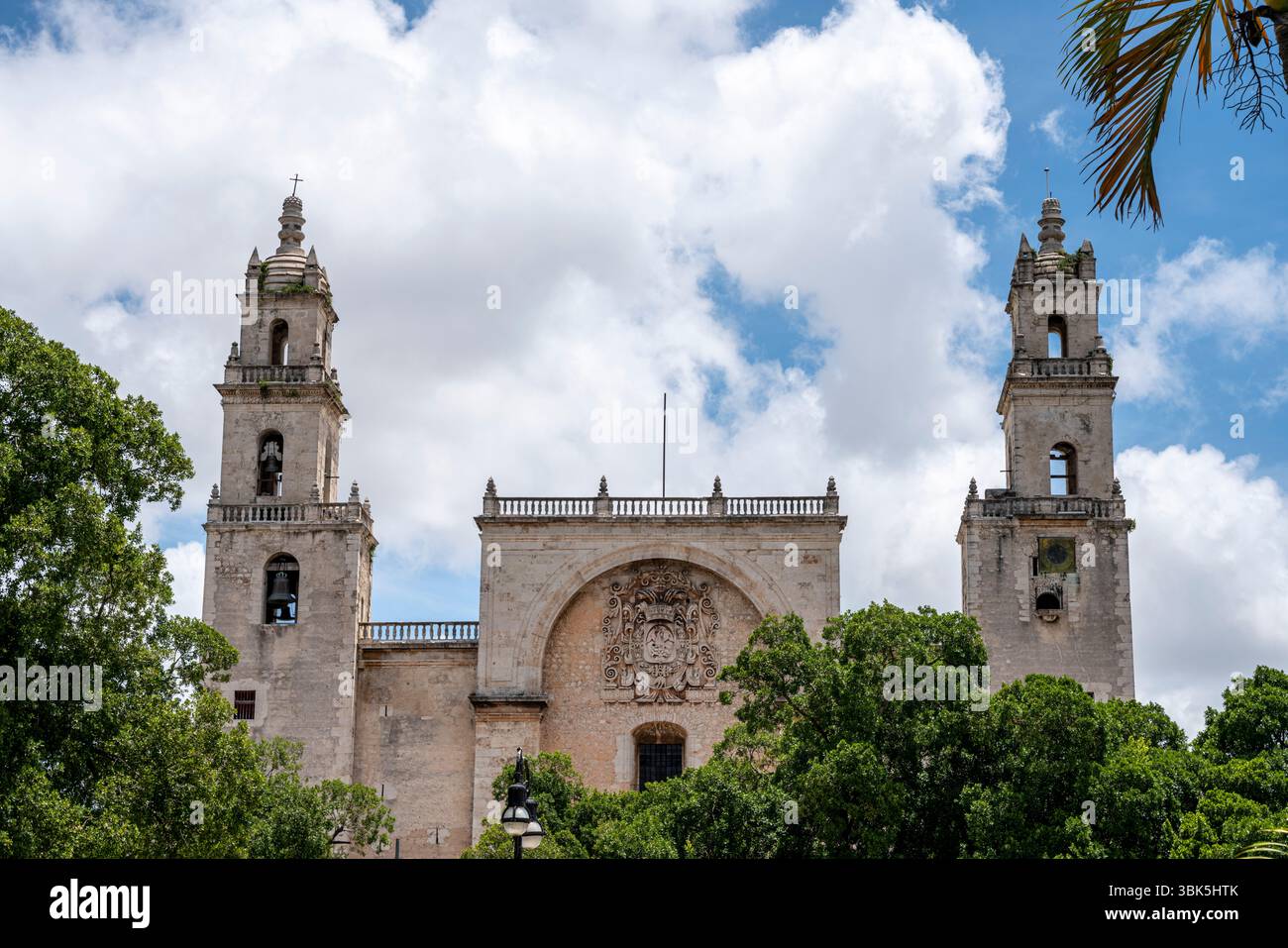 La cattedrale Ildefonso, due torri campanili barocche con facciata in pietra e cielo nuvoloso in Messico, penisola dello Yucatan, Merida. Foto Stock