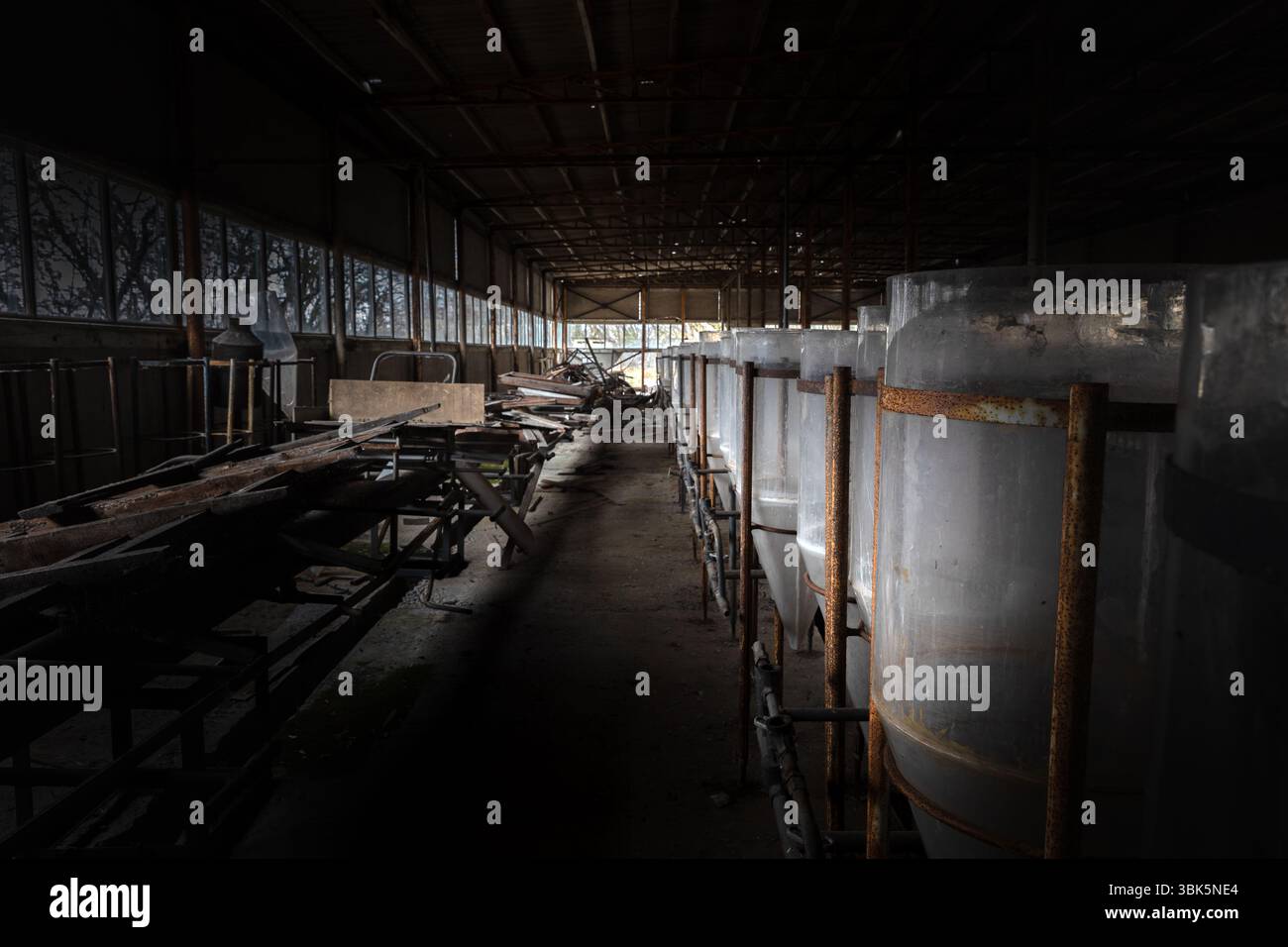 Industriali abbandonati interno con vasche di allevamento di angolazione Foto Stock