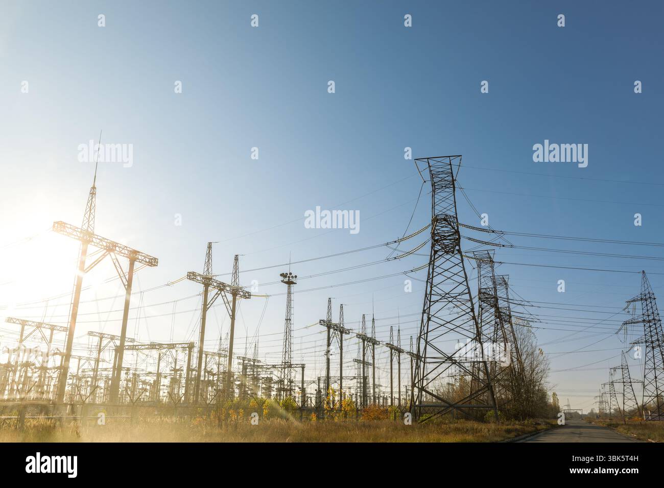 Grandi piloni a potenza stazione di distribuzione sotto il cielo blu Foto Stock