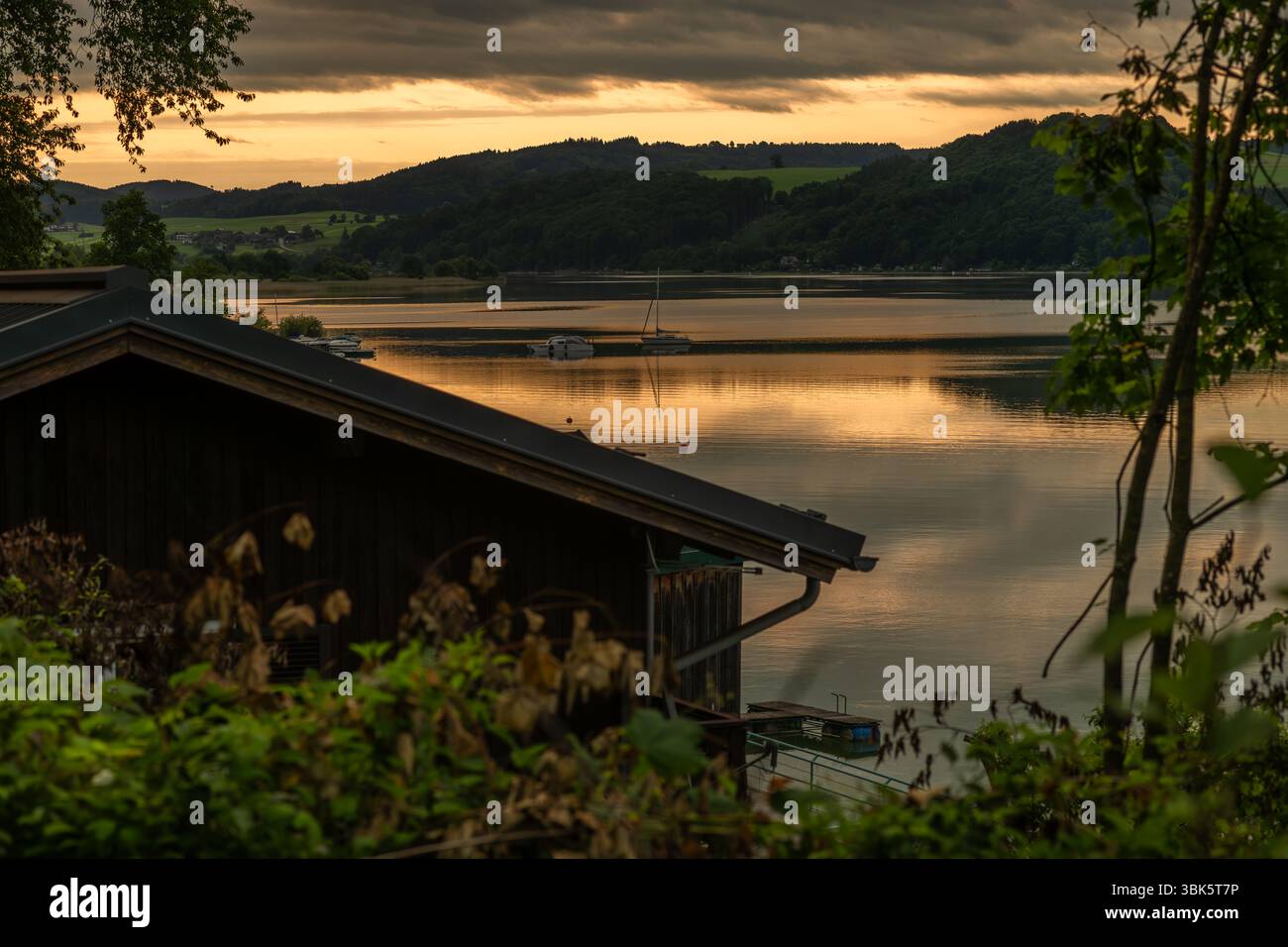 Alba mattutina di colore nuvoloso con acqua del lago Wallersee Austria 06 05 25 Foto Stock