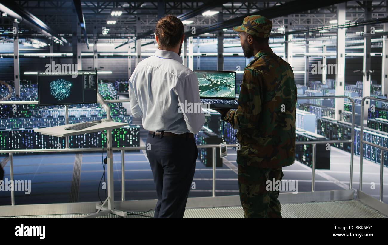 Specialisti IT militari in server hub che utilizzano strumenti di scanner per laptop per supervisionare il campo di battaglia durante la guerra. Amministratori dei data center dell'esercito che eseguono analisi della trasmissione e monitoraggio del sistema UAV in tempo reale Foto Stock