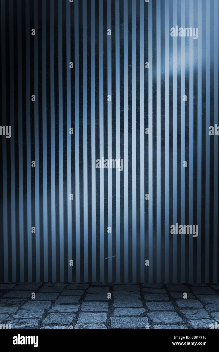 La parete metallica a righe viene mostrata in corridoio industriale, con pavimento in rete in ciottoli Foto Stock