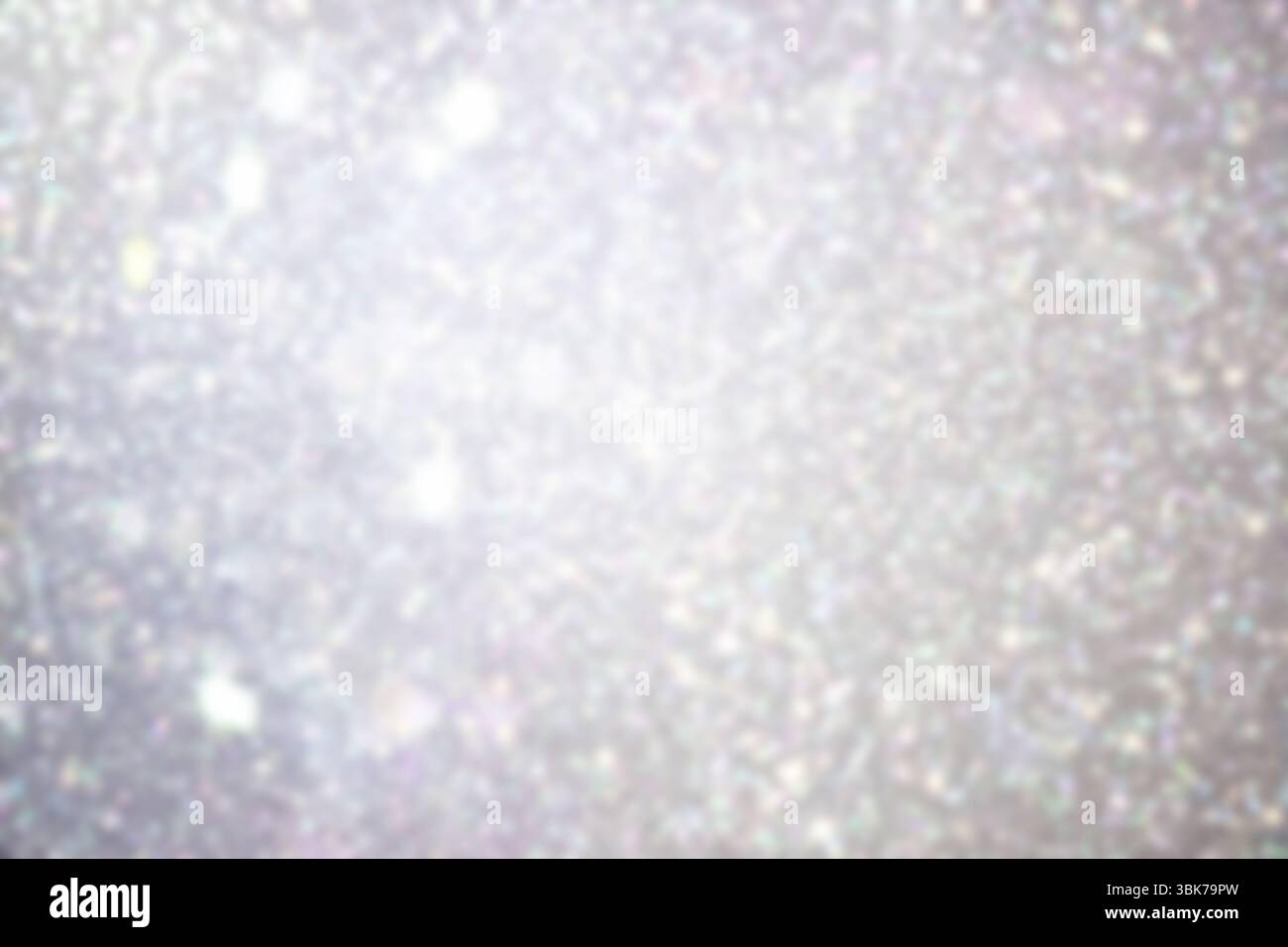 La macro astratta mostra particelle glitter in studio sotto una luce soffusa con un riflesso argenteo, bokeh Foto Stock