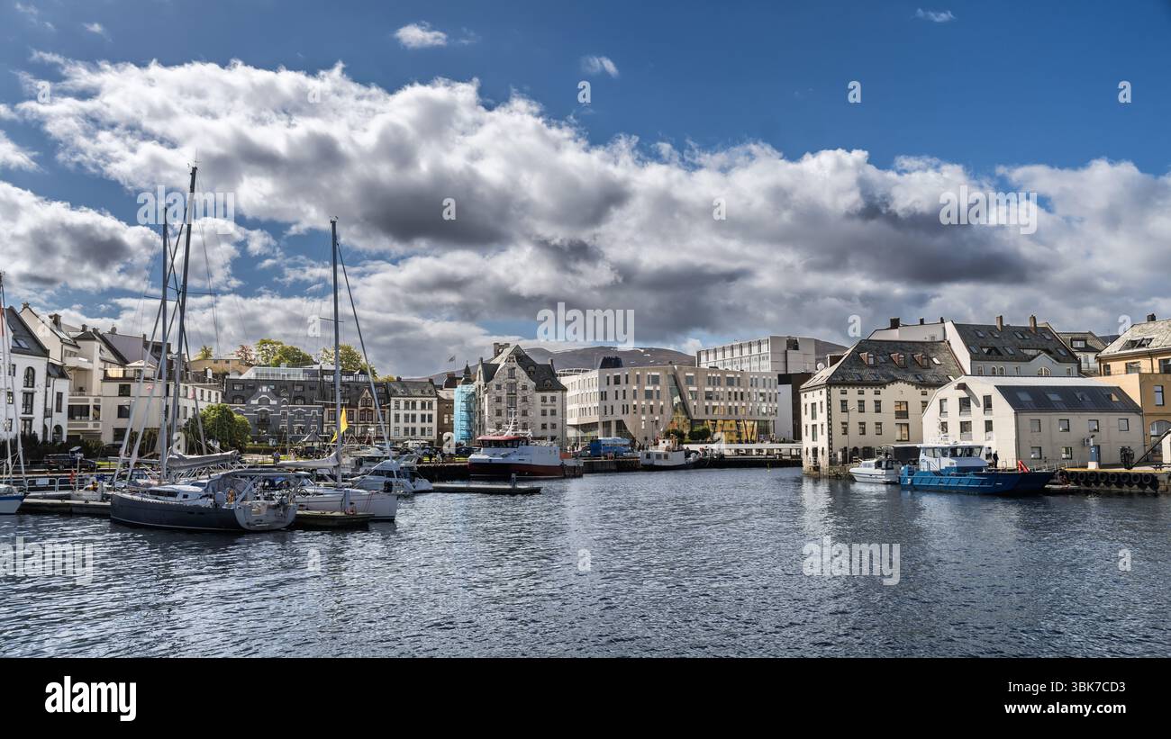 Vista pittoresca di un porto con barche a vela, affascinante architettura tradizionale e un cielo limpido, che evoca tranquillità e fascino della costa europea, Aales Foto Stock