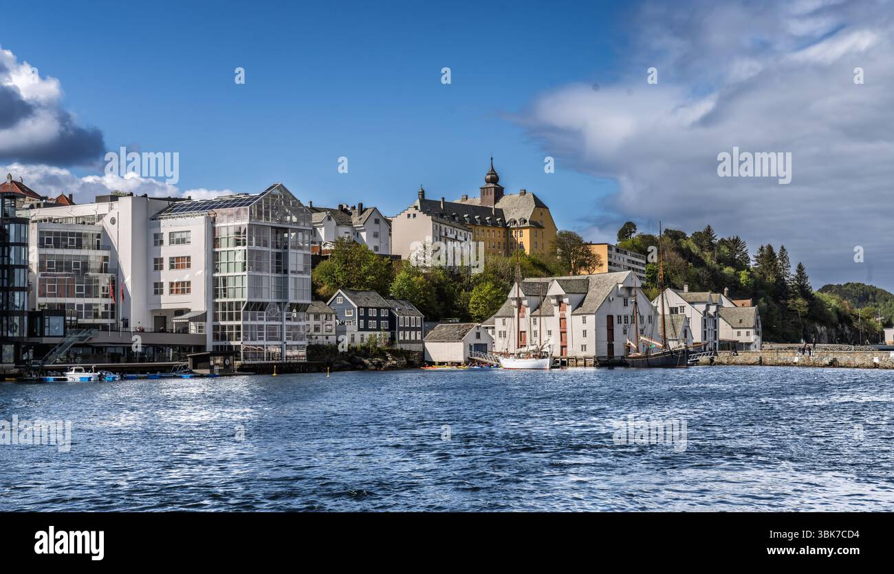 Architettura storica lungo un tranquillo lungomare adagiato su una lussureggiante collina verde con dettagli notevoli e un magnifico sfondo di una vivace blu Foto Stock