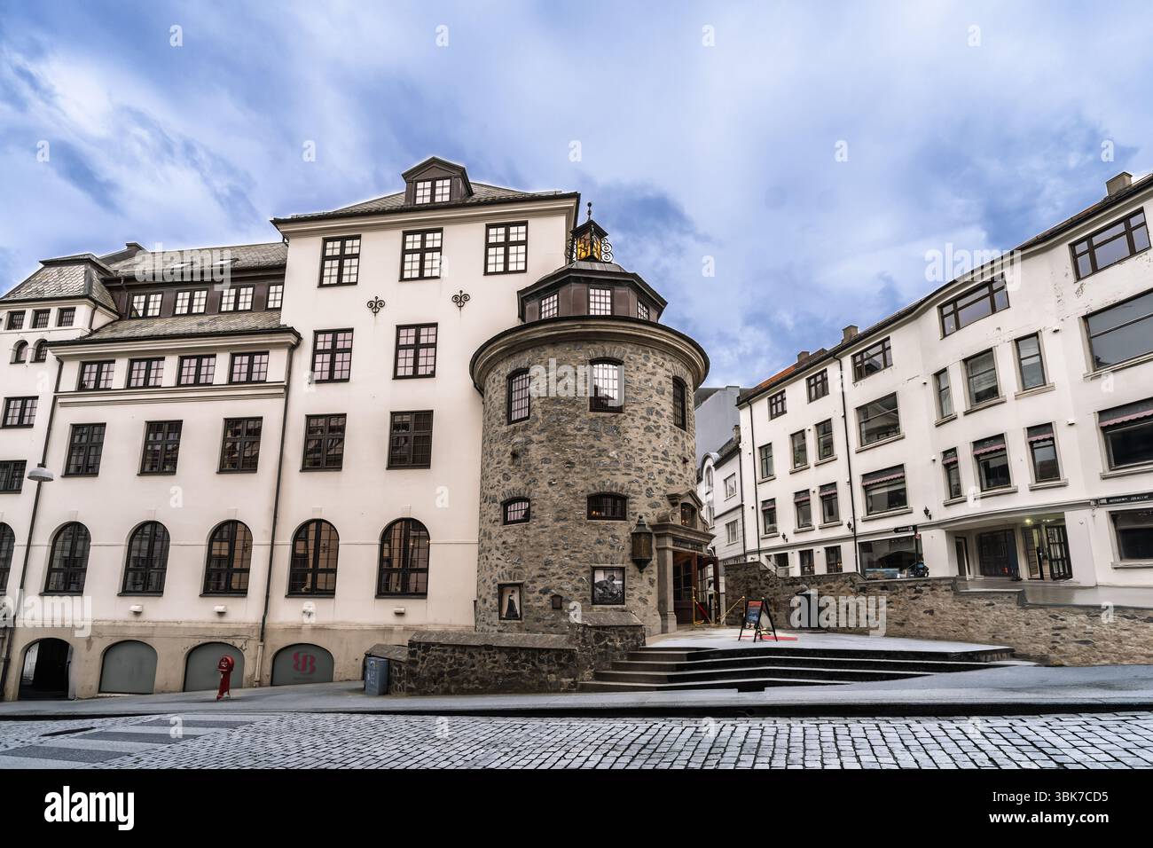 Vista panoramica dell'architettura storica con una torre medievale in pietra e classici edifici europei, catturando il fascino senza tempo. La combinazione di c Foto Stock