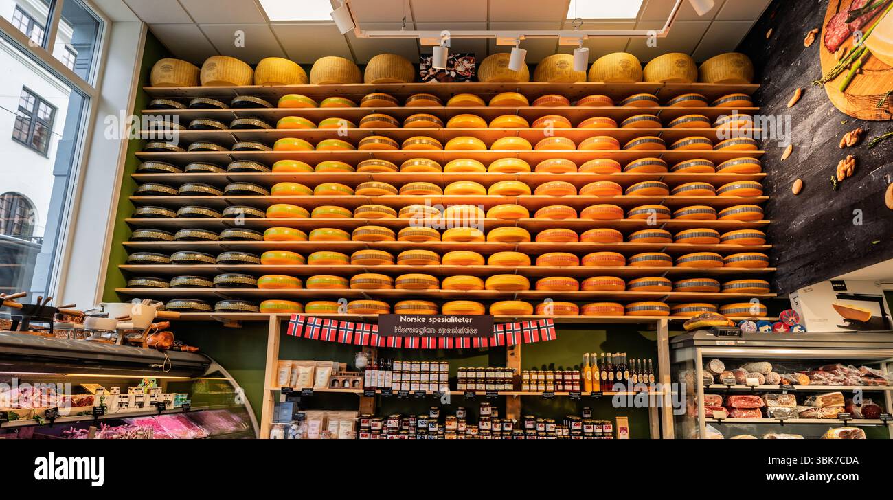 Una vivace esposizione di numerosi formaggi disposti su scaffali all'interno di un negozio di specialità alimentari, che mostra prodotti caseari e prelibatezze gourmet in un luminoso ambiente Foto Stock
