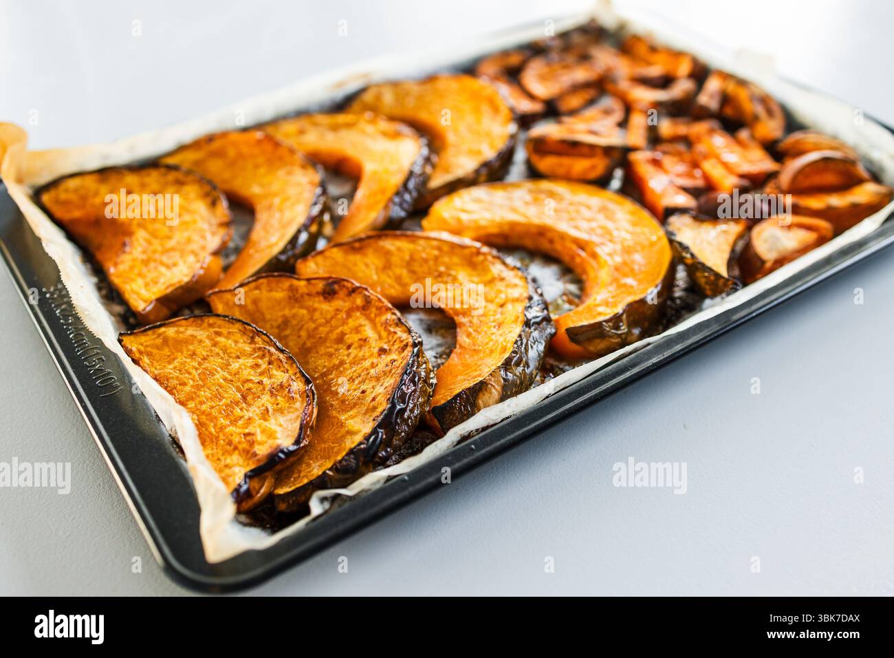 zucca kent a fette arrostite e patatine dolci su un vassoio da forno, ingredienti semplici e salutari Foto Stock zucca kent a fette arrostite e patatine dolci su un vassoio da forno, ingredienti semplici e salutari Foto Stock
