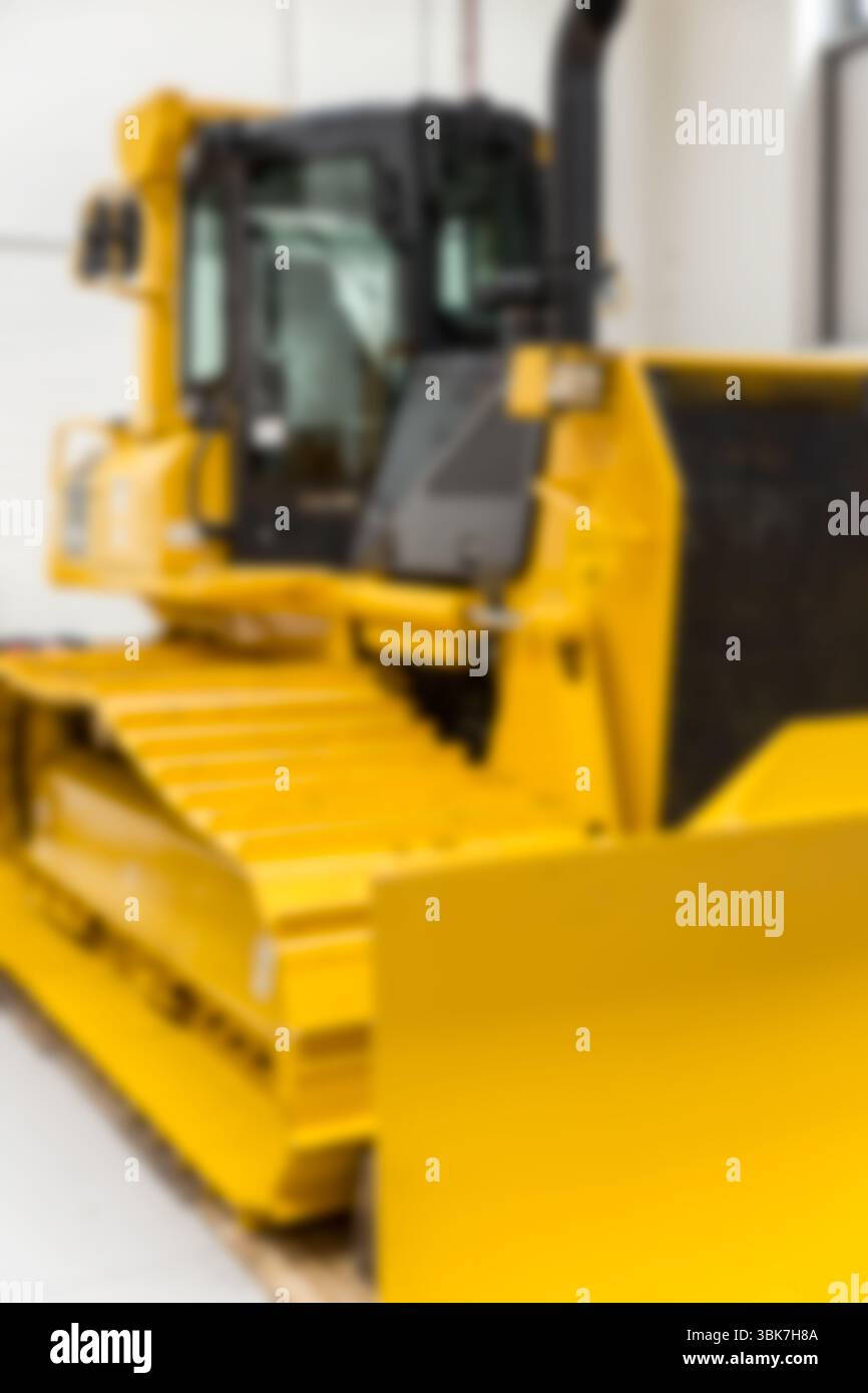 Il bulldozer giallo si trova all'interno di un magazzino con design piatto, mostrando i comandi della cabina e la lama anteriore Foto Stock