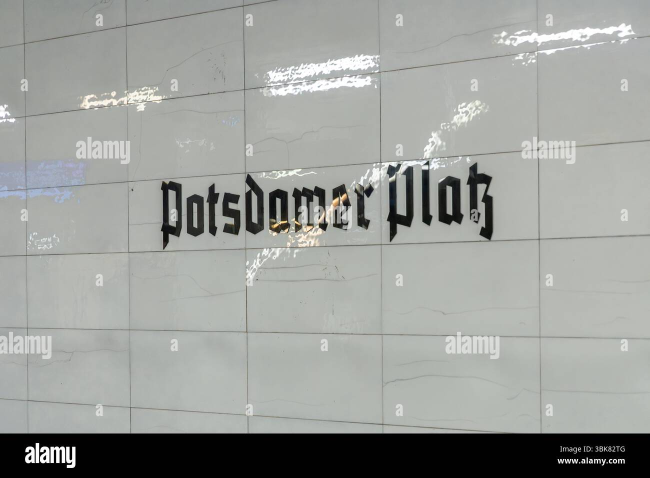 "Potsdamer Platz" con scritta gotica nera su una parete piastrellata bianca. Dettagli della stazione della metropolitana S-Bahn dei mezzi pubblici a Berlino, Germania. Berlino, Ger Foto Stock