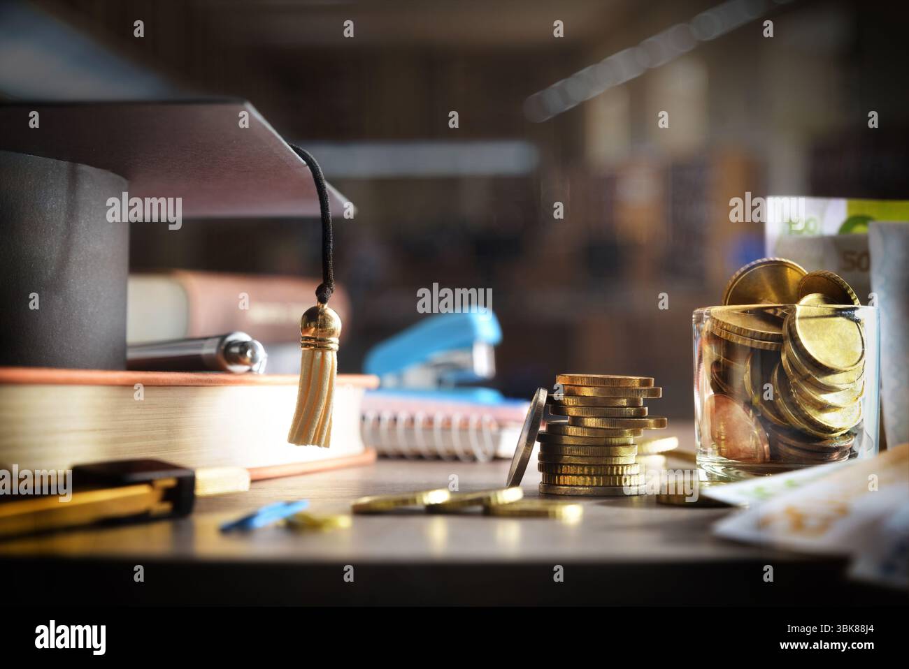 Costo elevato del concetto di istruzione con denaro e forniture educative su tavola di legno e sfondo oscuro isolato. Vista frontale. Foto Stock