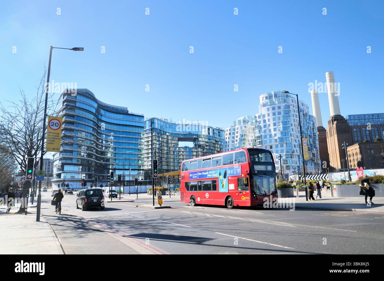 Auto, pedoni e autobus rosso a due piani su Battersea Park Road con appartamenti moderni sullo sviluppo della centrale elettrica di Battersea, Londra, Regno Unito, zona 20 mph Foto Stock