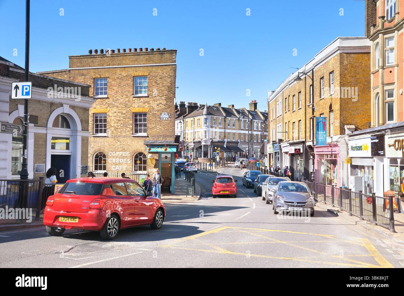 Auto che attraversano il Blackheath Village con il suo mix di negozi indipendenti, caffè, ristoranti e catene di negozi, South East London, Inghilterra, Regno Unito Foto Stock