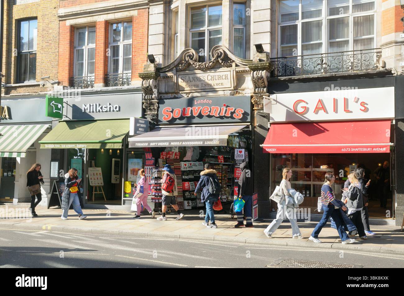 London Souvenirs Shop (all'ex entrata sud della chiesa di Sant'Anna) e turisti su Shaftesbury Avenue, West End di Londra, Inghilterra Regno Unito. negozi di souvenir Foto Stock
