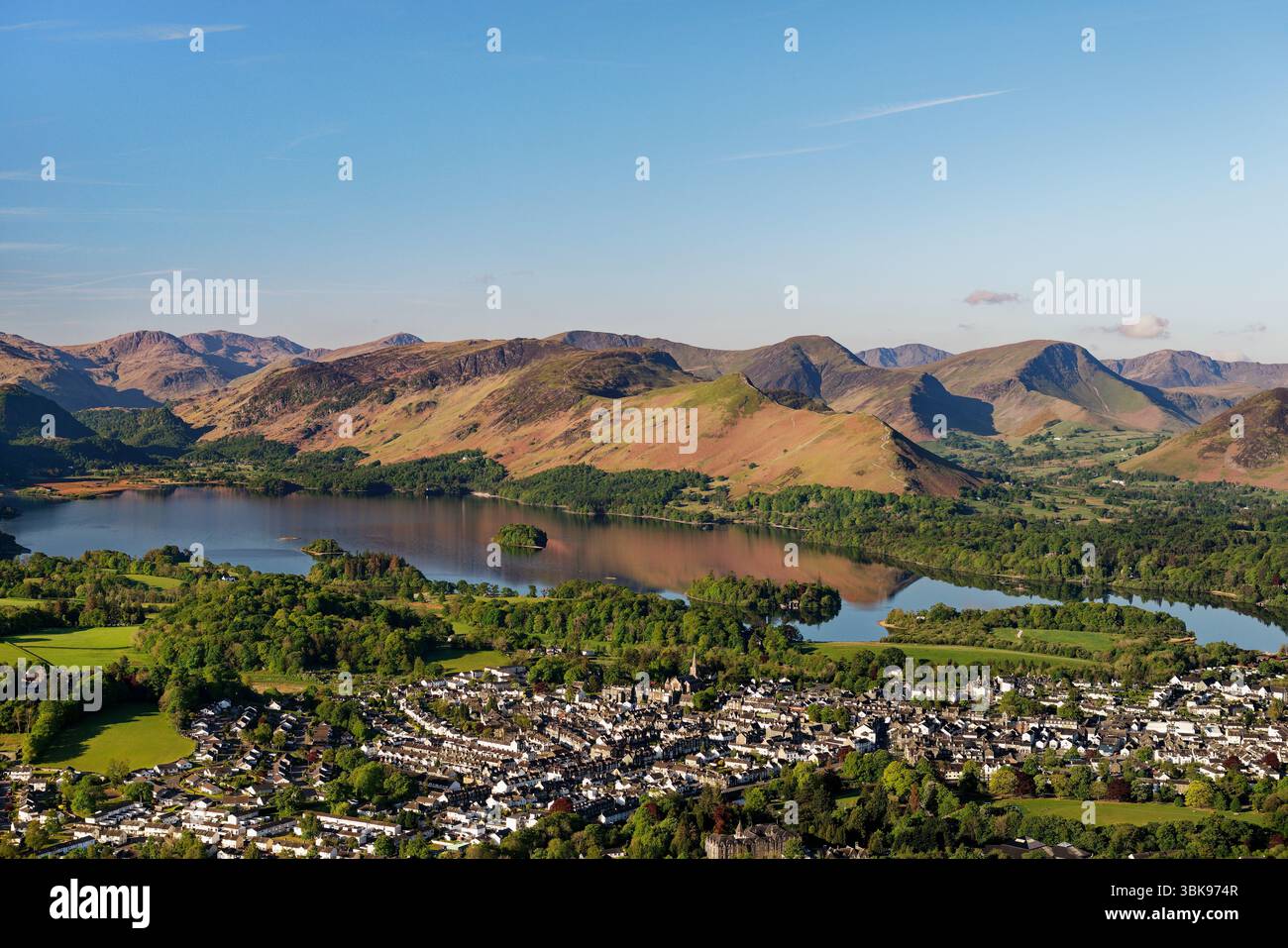 Sopra la città di Keswick e Derwentwater fino a Cat Bells e Newlands nel Lake District. La ruggine della salamoia invernale copre ancora le collane a maggio. Mattina presto Foto Stock