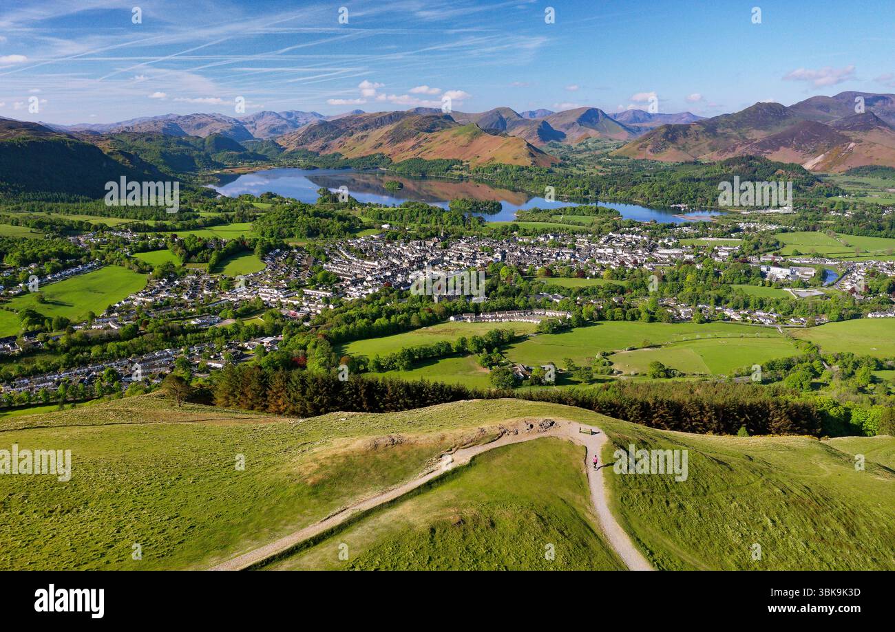 S.W. da Latrigg sopra la città di Keswick e Derwentwater fino a Borrowdale nel Lake District. La ruggine della salamoia invernale copre ancora le collane a maggio. Mattina presto Foto Stock