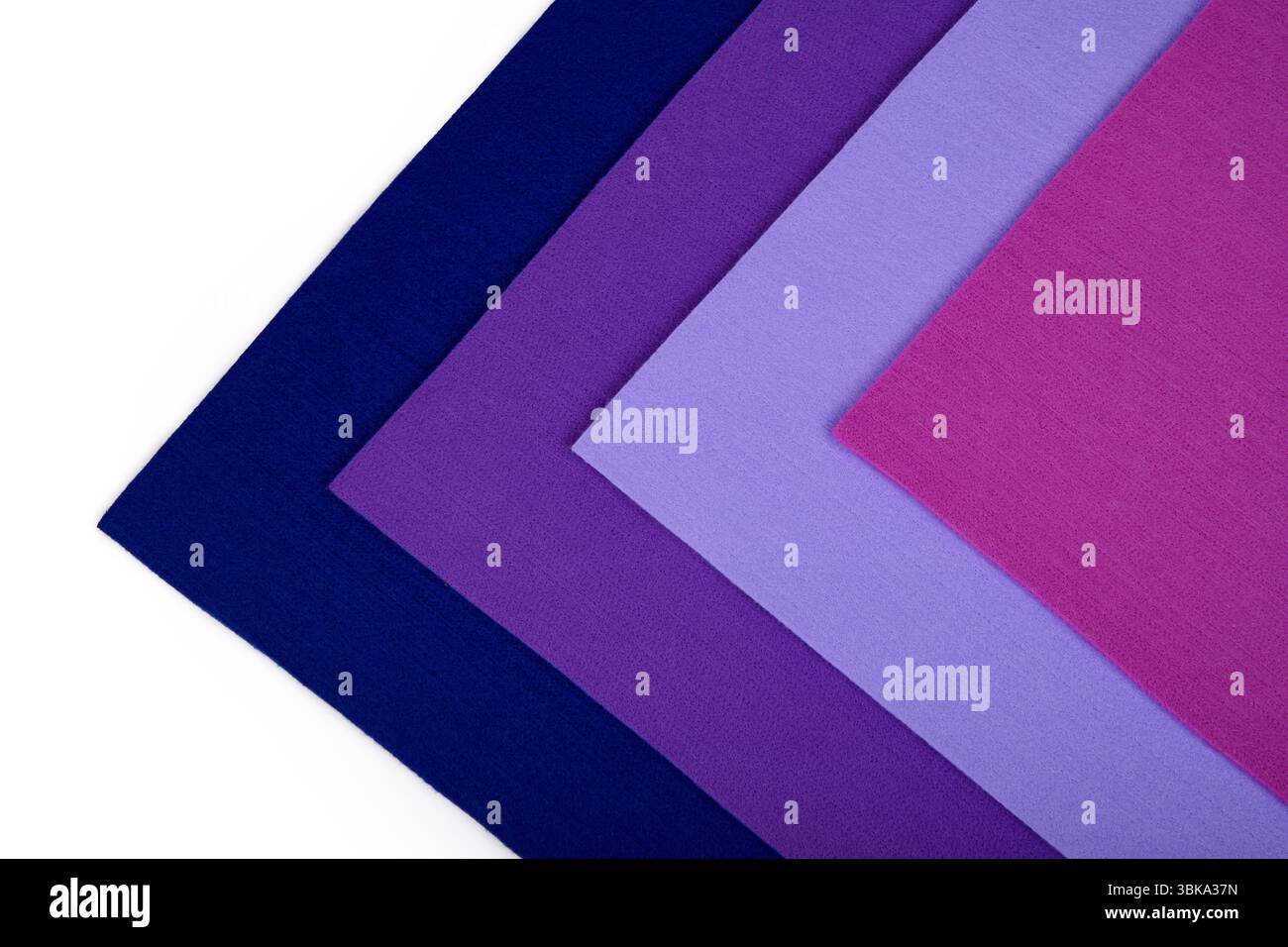 Fogli colorati in tessuto spessi in tonalità viola e rosa su sfondo bianco in forma triangolare. Foto Stock