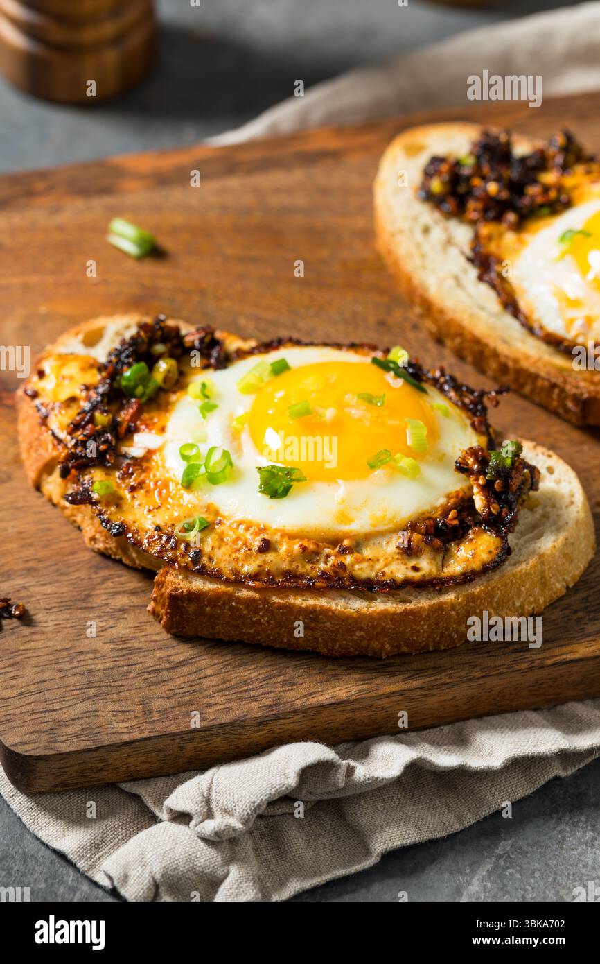 Uova fritte con olio croccante al peperoncino sano su pane tostato Foto Stock
